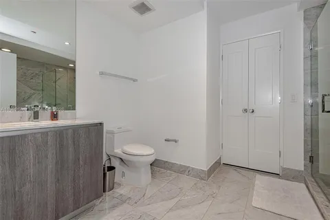 a bathroom with a toilet a sink a mirror and vanity