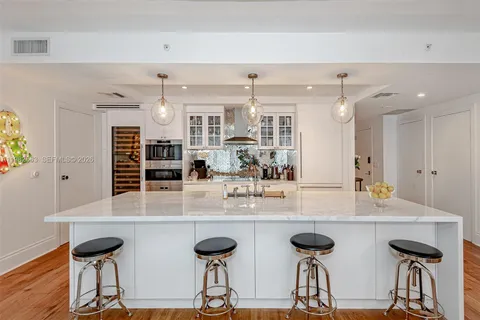 a kitchen with stainless steel appliances granite countertop a kitchen island a stove and a table