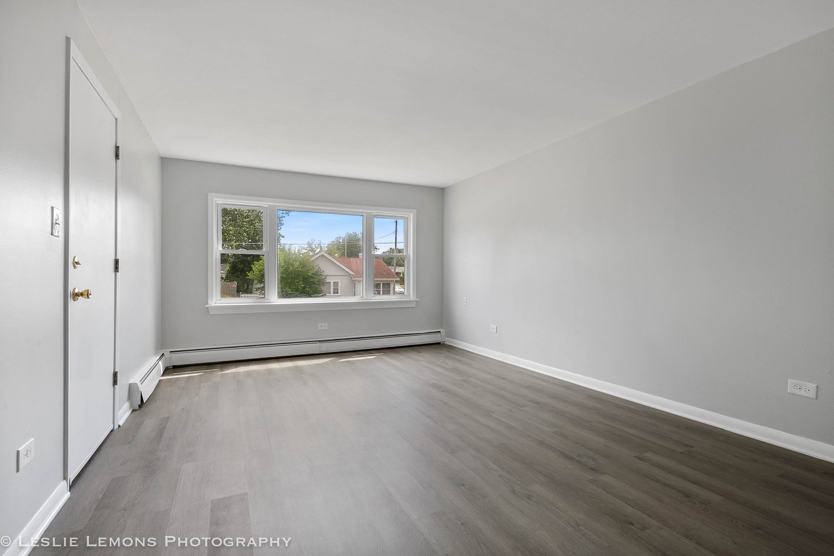 912 State Street, Unit 2 Lemont, IL 60439 - Photo 3 of 25 a view of an empty room with wooden floor and a window