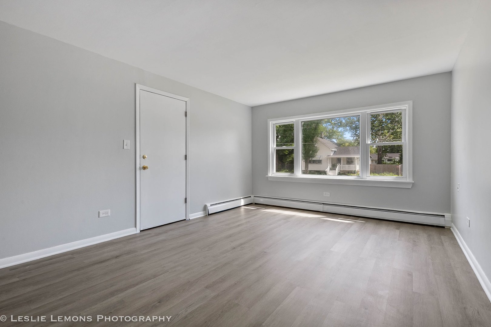 912 State Street, Unit 2 Lemont, IL 60439 - Photo 4 of 25 a view of an empty room with wooden floor and a window