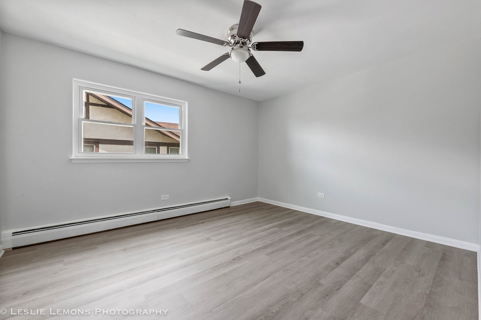 912 State Street, Unit 2 Lemont, IL 60439 - Photo 9 of 25 an empty room with a window and a fan
