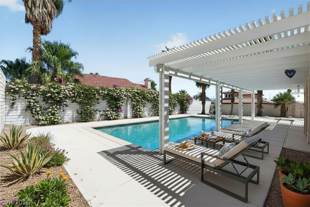 3698 Laughlin Boulevard Laughlin, NV 89029 - Photo 47 of 49 An inviting backyard oasis offers a sparkling pool with a lounging area shaded by a modern pergola.