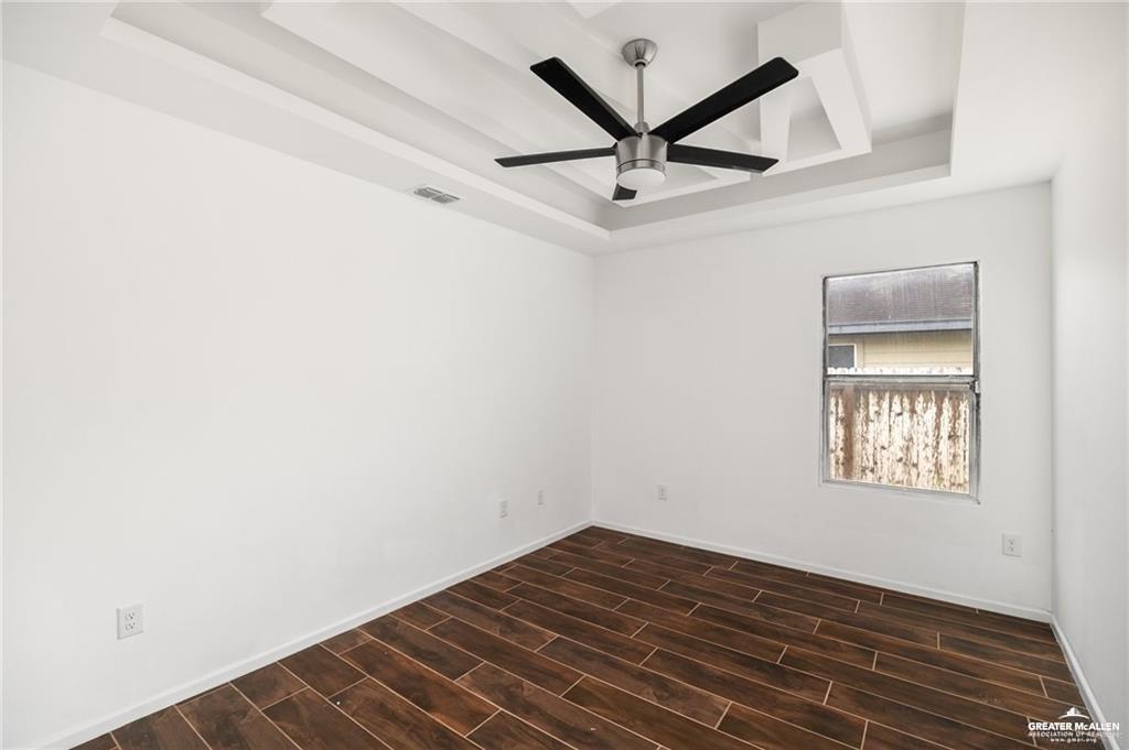 2105 Azalea Street Mission, TX 78573 - Photo 10 of 14 an empty room with wooden floor and windows