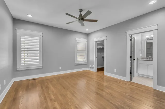 a view of an empty room with chandelier and wooden floor
