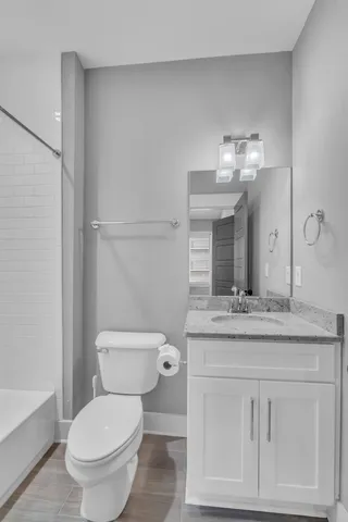 a bathroom with a granite countertop sink a mirror and a bathtub
