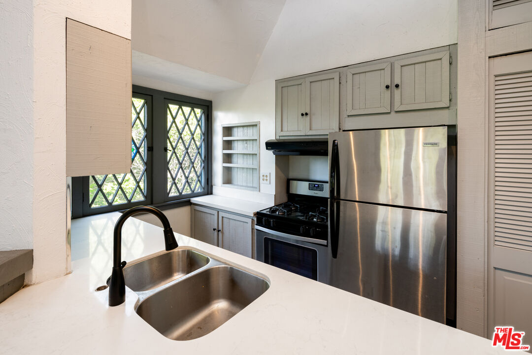 1954 Hillcrest Road, Unit 3 Los Angeles, CA 90068 - Photo 15 of 26 a kitchen with stainless steel appliances a refrigerator a sink a stove and cabinets