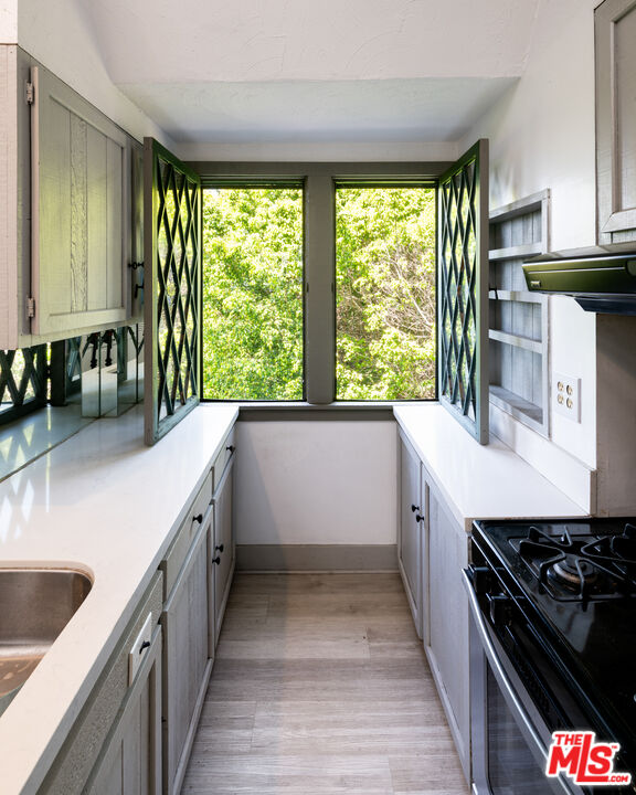1954 Hillcrest Road, Unit 3 Los Angeles, CA 90068 - Photo 16 of 26 a kitchen with a sink stove top oven and cabinets