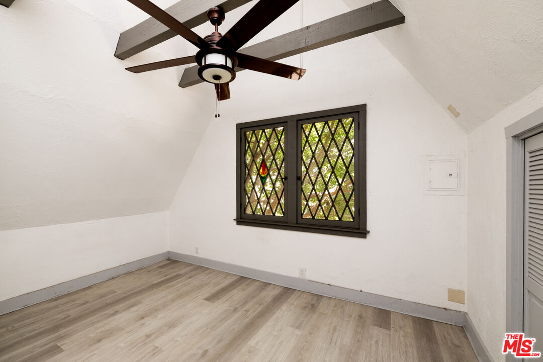 1954 Hillcrest Road, Unit 3 Los Angeles, CA 90068 - Photo 18 of 26 an empty room with wooden floor fan and windows