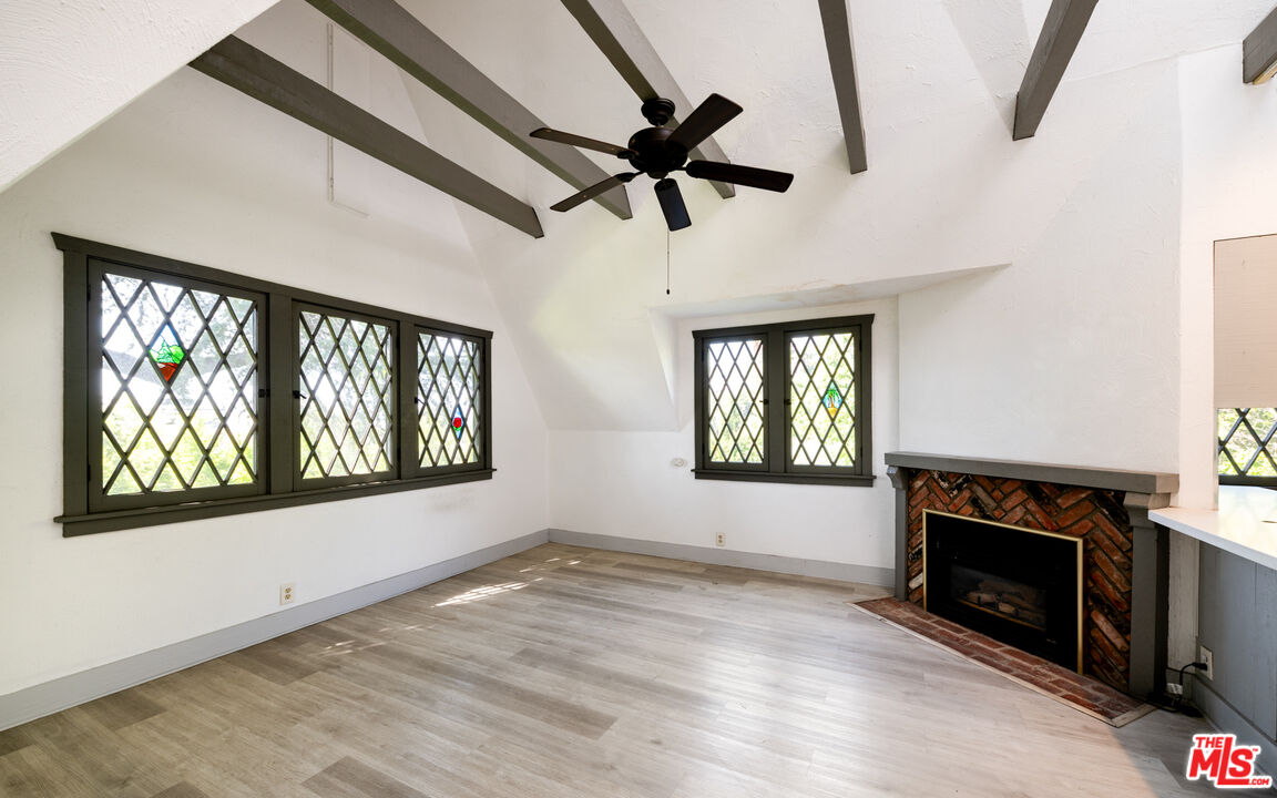 1954 Hillcrest Road, Unit 3 Los Angeles, CA 90068 - Photo 8 of 26 an empty room with windows fireplace and wooden floor