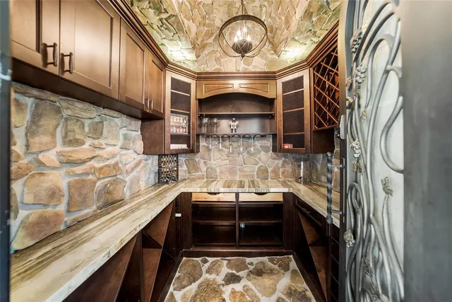 a dining room with chandelier and wooden floor