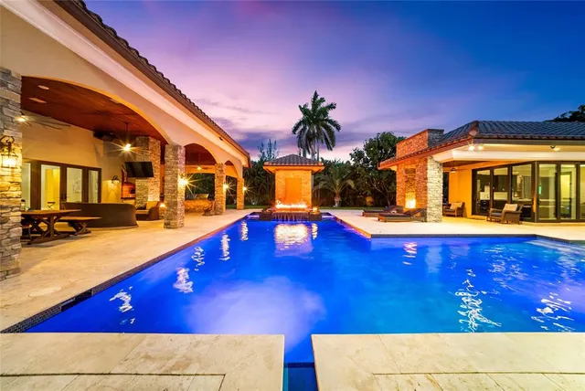 a view of a house with a yard and palm trees