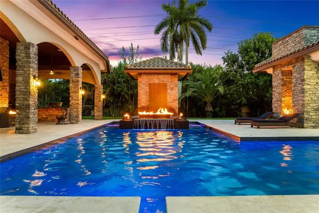 a front view of a house with garden and swimming pool
