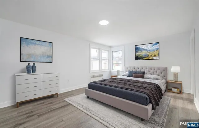 a spacious bedroom with a bed and a flat screen tv