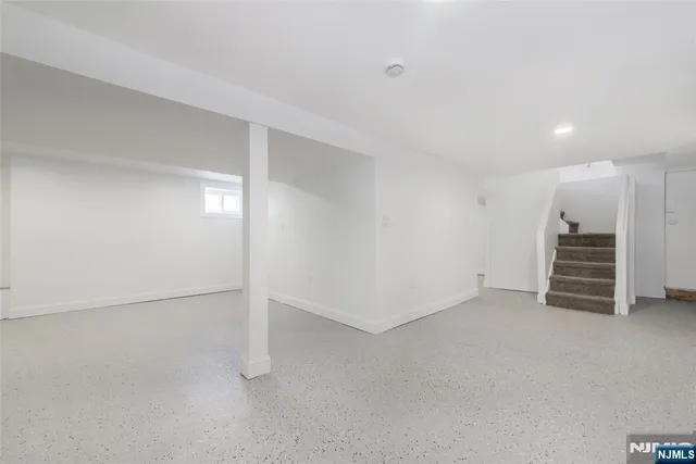 an empty room with a cabinet and mirrors