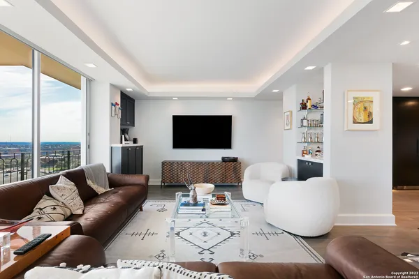 a living room with furniture kitchen view and a window