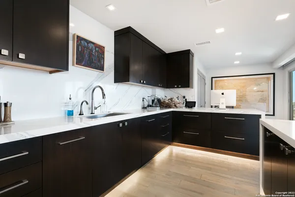 a kitchen with a sink appliances and cabinets