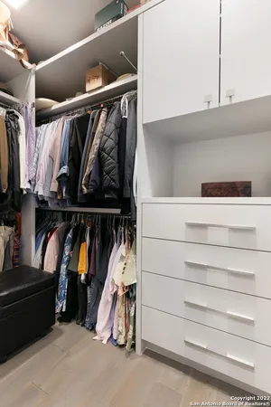 a view of a hallway with furniture and a potted plant