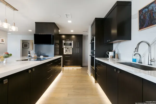 a large kitchen with stainless steel appliances a sink counter space and cabinets