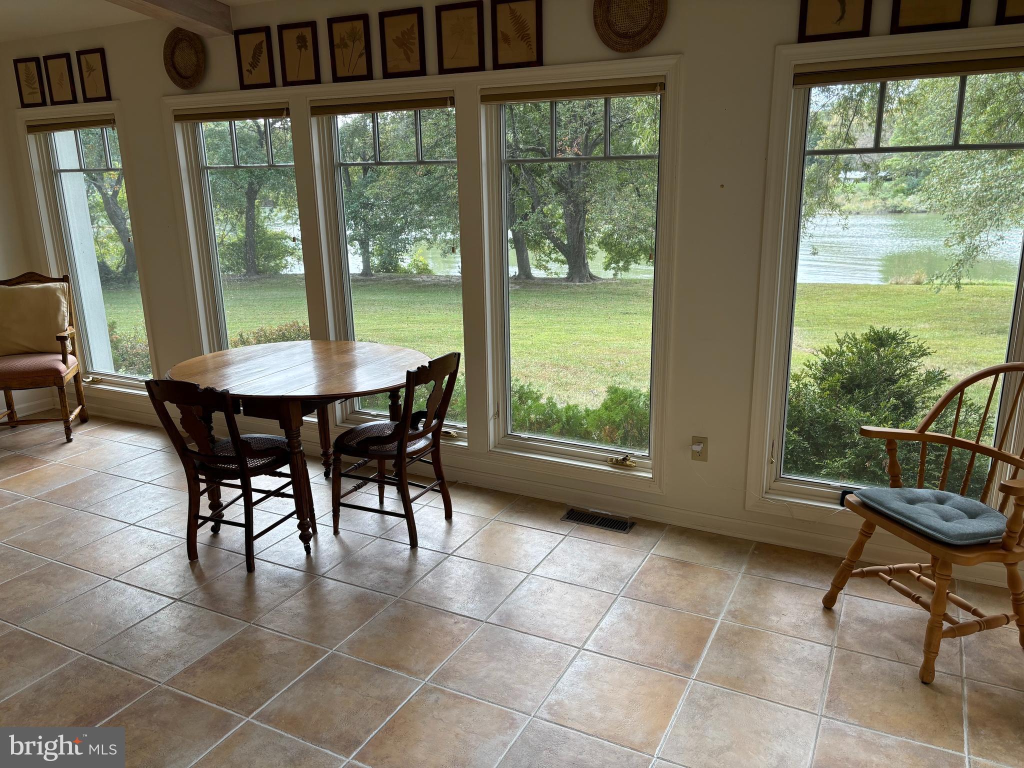 6680 Peachblossom Point Road Easton, MD 21601 - Photo 22 of 35 a dining room with furniture and a floor to ceiling window