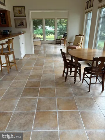 a dining room with furniture and a floor to ceiling window