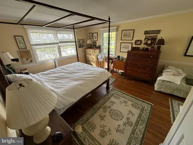 a bedroom with a bed window and wooden floor