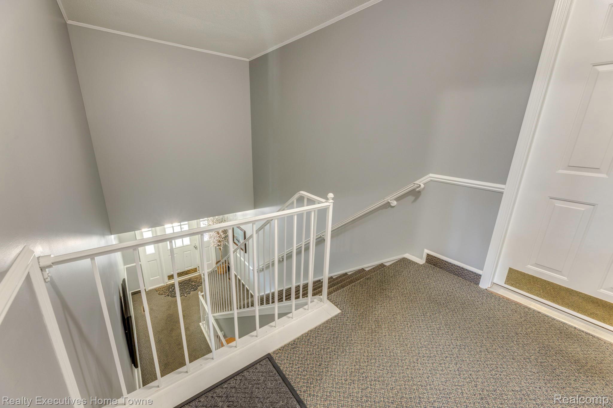 1467 Krafft Road, Unit 8 Port Huron, MI 48060 - Photo 22 of 30 Carpeted stairway with white railing and handrail