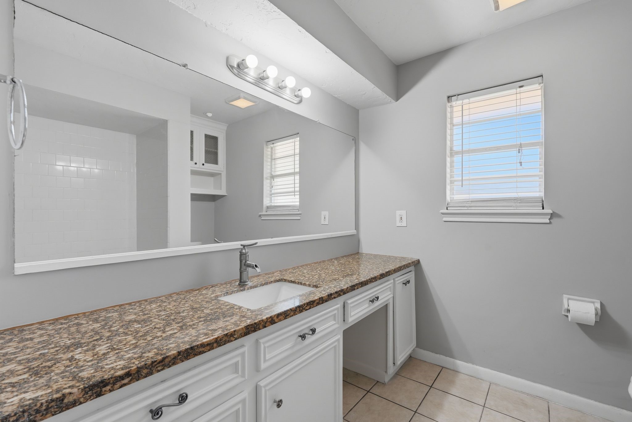 25611 Timberlane Drive Spring, TX 77386 - Photo 27 of 38 a bathroom with a granite countertop sink and a mirror