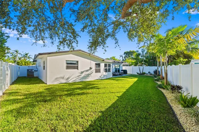 a view of a house with backyard and a tree