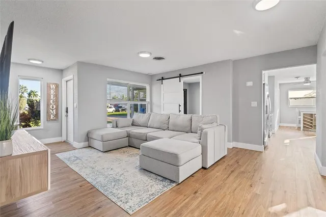 a living room with furniture and a wooden floor