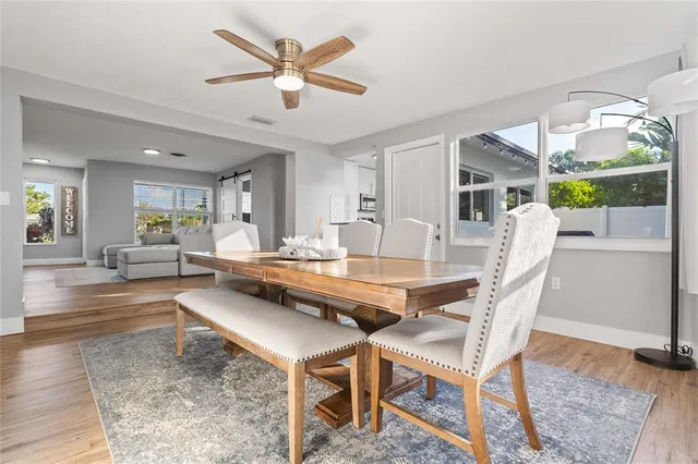 a dining hall with stainless steel appliances granite countertop a dining table and chairs with wooden floor