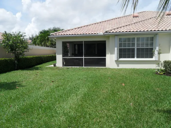 a front view of a building with yard and sign board