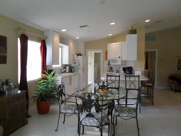 a view of a dining room with furniture and potted plants