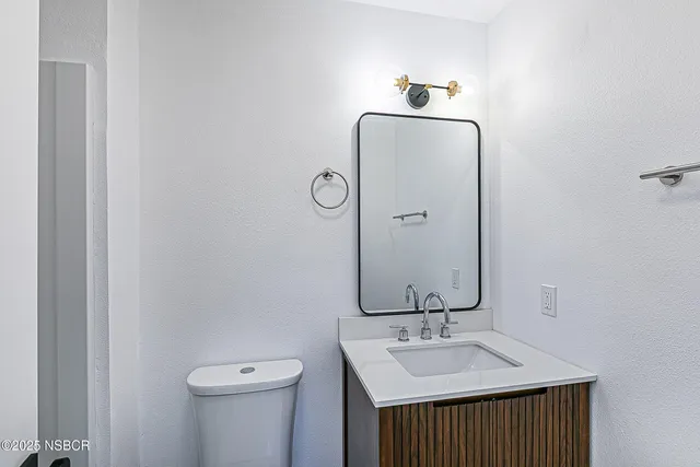 a bathroom with a sink and mirror with toilet
