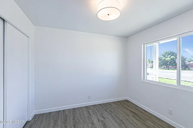 a view of a room with wooden floor and windows