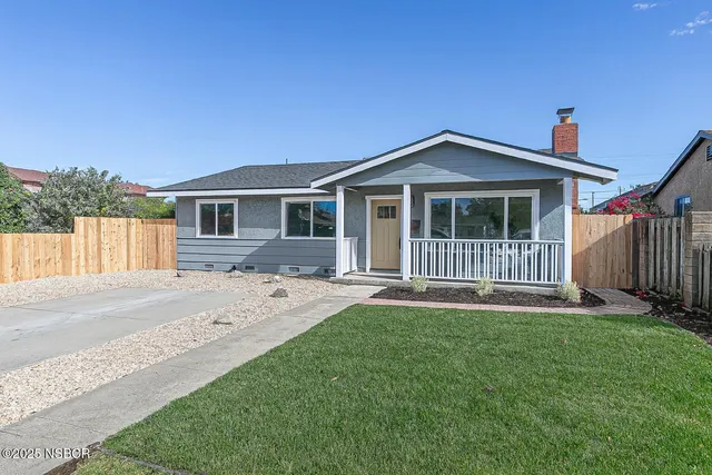 a front view of a house with a garden and yard