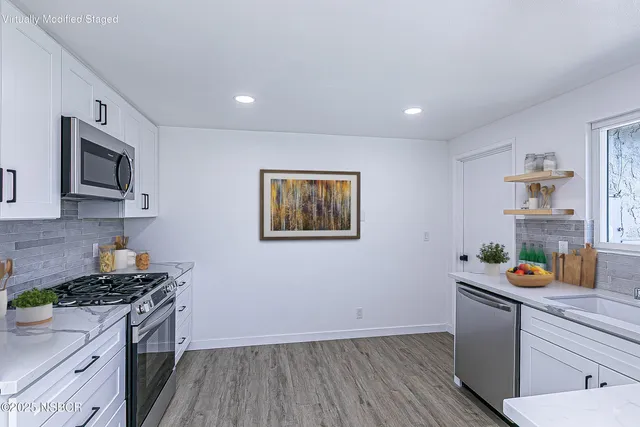 a kitchen with a sink and wooden floor