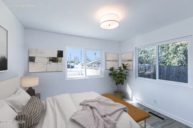 a bedroom with furniture and a large window