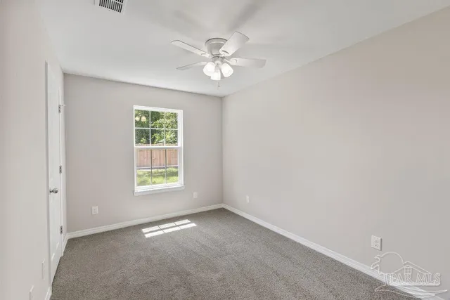an empty room with a window and a fan