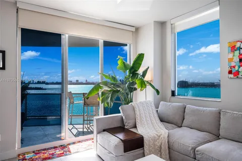 a living room with furniture plant and a window