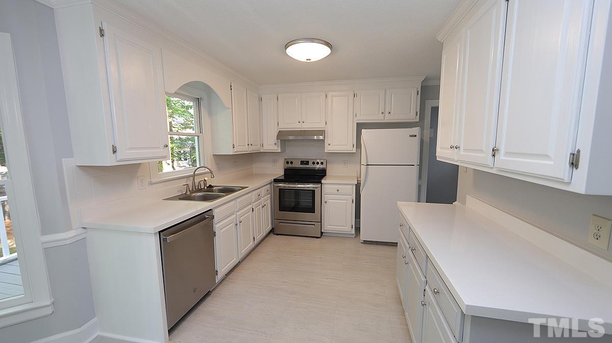 4505 Fortingale Circle Raleigh, NC 27613 - Photo 5 of 14 a kitchen with granite countertop white cabinets and white appliances