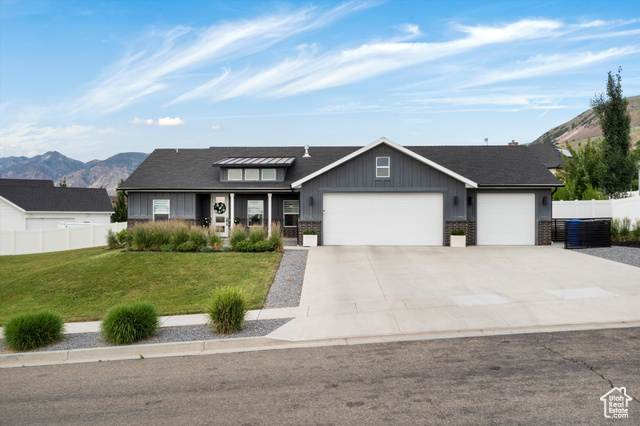 1873 165 West Perry, UT 84302 - Photo 1 of 1 View of front of house featuring an attached garage, board and batten siding, driveway, and a mountain view