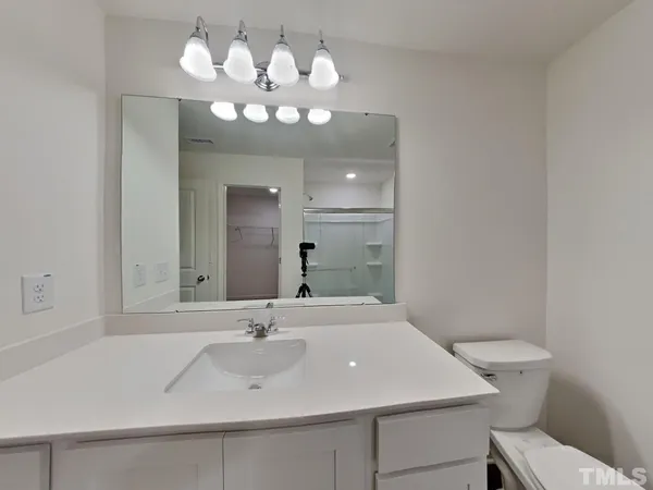a bathroom with a sink a large mirror and a toilet