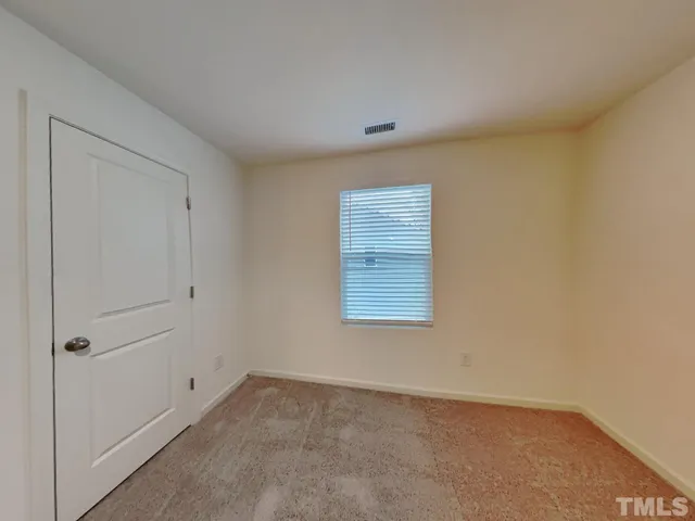 an empty room with a cabinet and mirrors