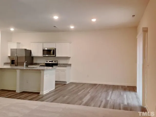 a kitchen with stainless steel appliances a refrigerator and microwave