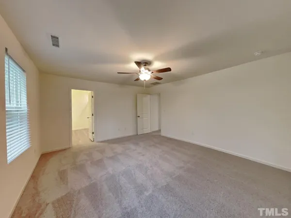 a view of an empty room with a ceiling fan