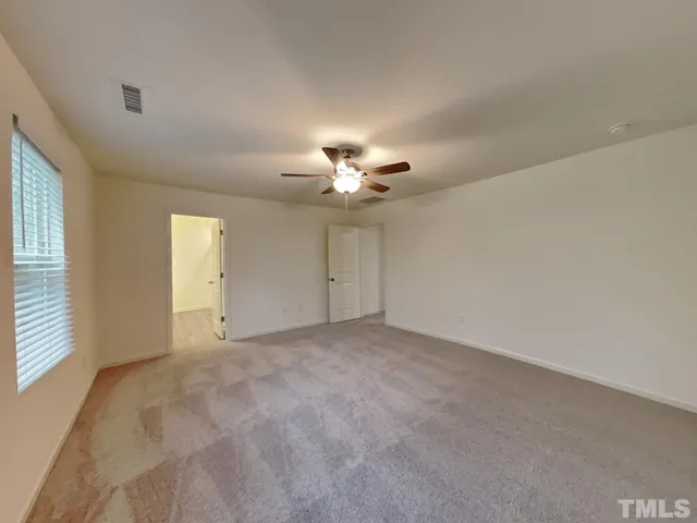 a view of an empty room with a ceiling fan