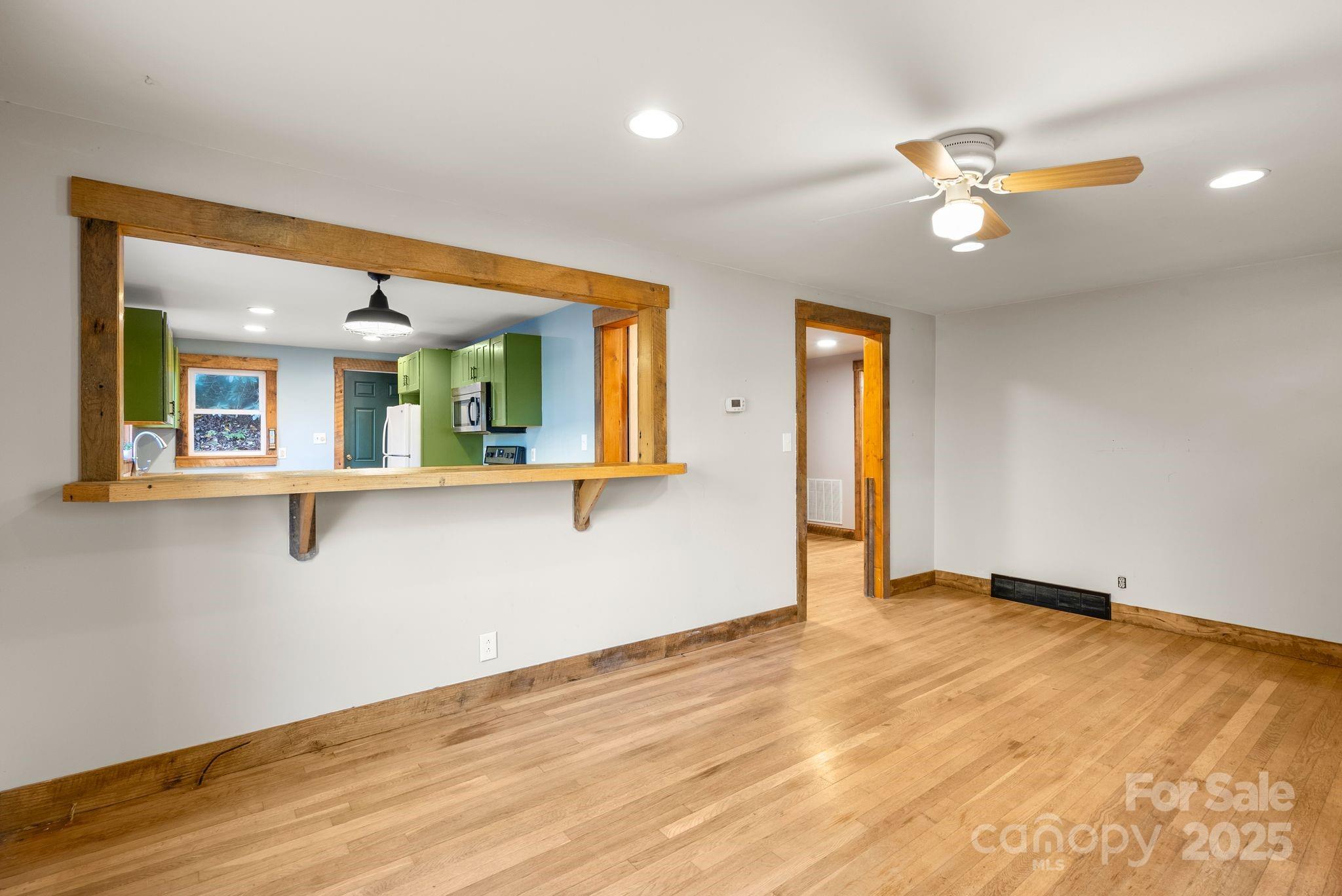 456 Rector Corner Road Marshall, NC 28753 - Photo 12 of 29 a view of an empty room with wooden floor and a chandelier