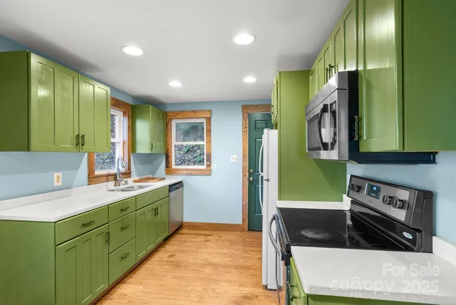 a kitchen with stainless steel appliances a sink stove and cabinets