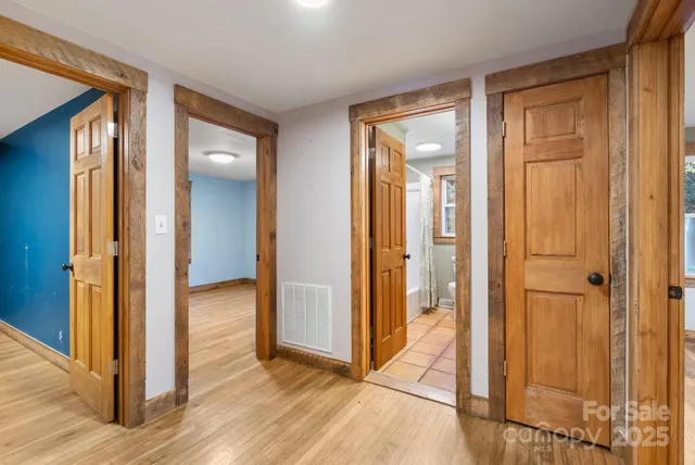wooden view of a hallway with wooden floor and closet area