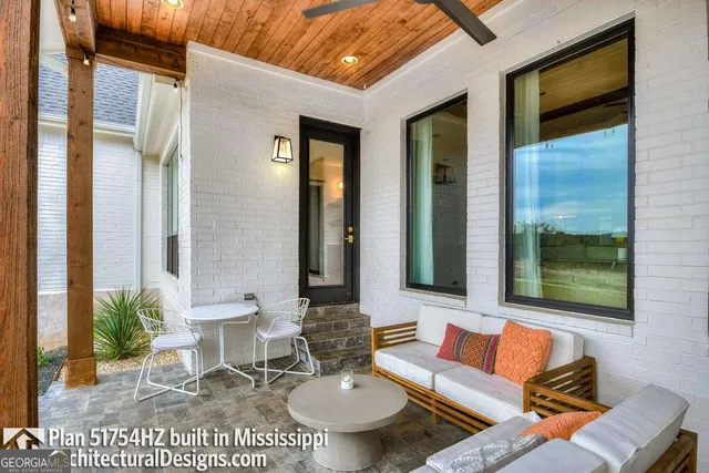 a outdoor space with patio couches a fireplace and a potted plant